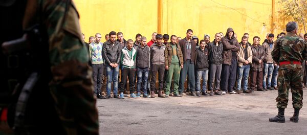 Members of government military police stand guard as men, who were evacuated from the eastern districts of Aleppo, are being prepared to begin their military service at a police centre in Aleppo, Syria December 11, 2016. - Sputnik International