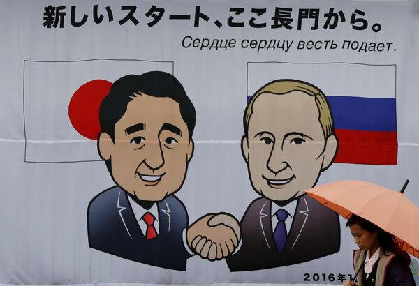 A woman walks past a banner showing Japan's Prime Minister Shinzo Abe and Russian President Vladimir Putin at the Senzaki station in Nagato, Yamaguchi prefecture, Japan, December 14, 2016 - Sputnik International