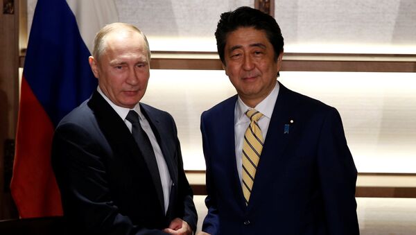 Russia's President Vladimir Putin (L) shakes hands with Japan's Prime Minister Shinzo Abe at the start of their summit meeting in Nagato, Yamaguchi prefecture, Japan, December 15, 2016. - Sputnik International