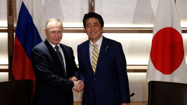 Russia's President Vladimir Putin (L) shakes hands with Japan's Prime Minister Shinzo Abe at the start of their summit meeting in Nagato, Yamaguchi prefecture, Japan, December 15, 2016. - Sputnik International