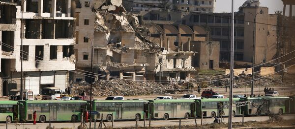 Buses are seen parked in Aleppo's government controlled area of Ramouseh, as they wait to evacuate civilians and rebels from eastern Aleppo, Syria December 15, 2016 - Sputnik International