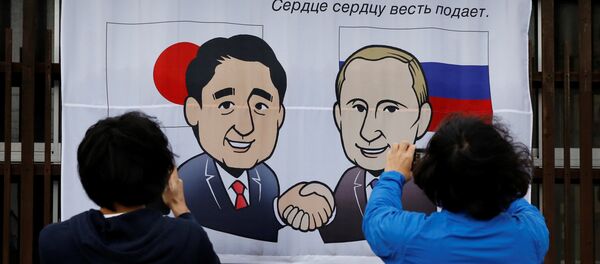 People take photos of a banner showing Japan's Prime Minister Shinzo Abe and Russian President Vladimir Putin at the Senzaki station in Nagato, Yamaguchi prefecture, Japan, December 14, 2016, a day before their summit meeting. The words on top reads, A new start from here in Nagato. People take photos of a banner showing Japan's Prime Minister Shinzo Abe and Russian President Vladimir Putin at the Senzaki station in Nagato, Yamaguchi prefecture, Japan, December 14, 2016, a day before their summit meeting. The words on top reads, A new start from here in Nagato. - Sputnik International