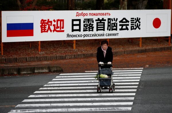 A woman walks in front of a sign board that reads Welcome Japan Russia summit meeting near a hot spring resort, the venue of the summit meeting between Japanese Prime Minister Shinzo Abe and Russian President Vladimir Putin, in Nagato, Yamaguchi prefecture, Japan, December 15, 2016. - Sputnik International