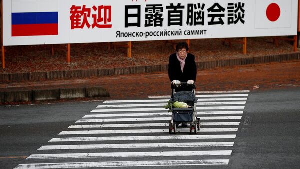A woman walks in front of a sign board that reads Welcome Japan Russia summit meeting near a hot spring resort, the venue of the summit meeting between Japanese Prime Minister Shinzo Abe and Russian President Vladimir Putin, in Nagato, Yamaguchi prefecture, Japan, December 15, 2016. - Sputnik International