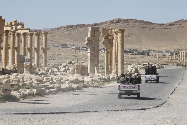 Syrian army soldiers drive past the Arch of Triumph in the historic city of Palmyra, in Homs Governorate, Syria. (File) - Sputnik International