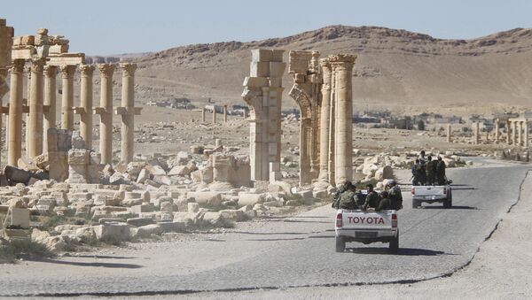 Syrian army soldiers drive past the Arch of Triumph in the historic city of Palmyra, in Homs Governorate, Syria. (File) - Sputnik International