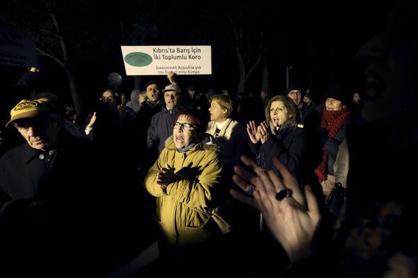 Greek and Turkish Cypriots protest outside of the presidential palace during a march for a peace in Nicosia, Cyprus, on Wednesday, Dec. 14, 2016. Some 250 Greek and Turkish Cypriots marched in support of a peace accord reunifying ethnically divided Cyprus ahead of a summit that will likely decide whether or not a deal is possible. The sign reads: 'Bicommunal Choir for Peace in Cyprus.' Greek and Turkish Cypriots protest outside of the presidential palace during a march for a peace in Nicosia, Cyprus, on Wednesday, Dec. 14, 2016. Some 250 Greek and Turkish Cypriots marched in support of a peace accord reunifying ethnically divided Cyprus ahead of a summit that will likely decide whether or not a deal is possible. The sign reads: 'Bicommunal Choir for Peace in Cyprus.' - Sputnik International