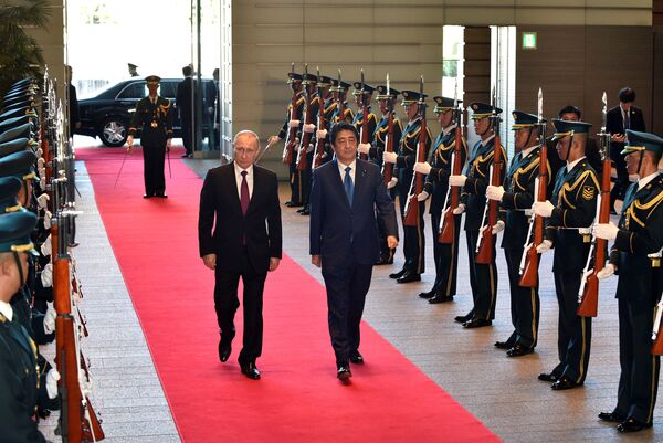 Russian President Vladimir Putin (L) and Japanese Prime Minister Shinzo Abe review an honor guard before their working lunch at Abe's official residence in Tokyo, Japan, December 16, 2016. - Sputnik International