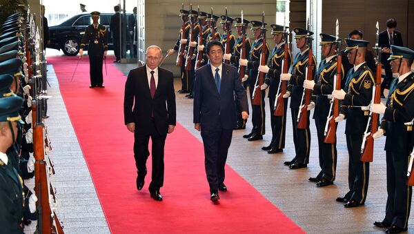 Russian President Vladimir Putin (L) and Japanese Prime Minister Shinzo Abe review an honor guard before their working lunch at Abe's official residence in Tokyo, Japan, December 16, 2016. - Sputnik International