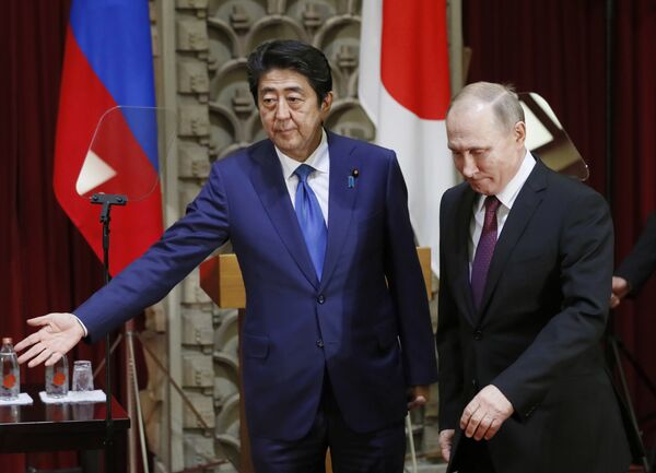 Japanese Prime Minister Shinzo Abe, left, shows the way to Russian President Vladimir Putin during a joint press conference in Tokyo, Japan, Friday, Dec. 16, 2016 - Sputnik International