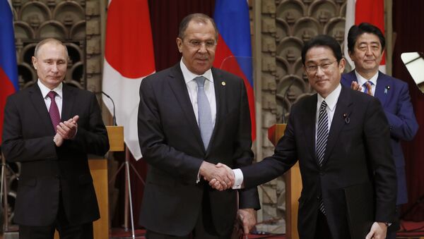 Russian President Vladimir Putin, left, and Japanese Prime Minister Shinzo Abe, rear right, applaud as Russian Foreign Minister Sergey Lavrov, second left, and his Japanese counterpart Fumio Kishida shake hands after exchanging the signed agreement in Tokyo, Japan, Friday, Dec. 16, 2016. - Sputnik International