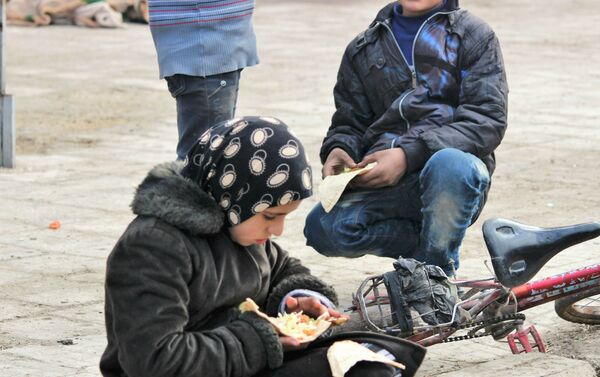 Child eating food being provided by the Syrian Government and Russia humanitarian organisations. Hanano, East Aleppo - Sputnik International