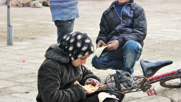 Child eating food being provided by the Syrian Government and Russia humanitarian organisations. Hanano, East Aleppo - Sputnik International