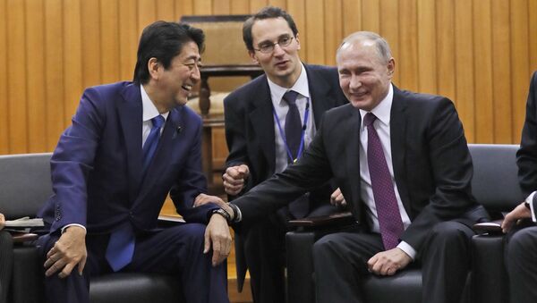 Russian President Vladimir Putin and Japanese Prime Minister Shinzo Abe share a light moment during their visit at Kodokan judo hall in Tokyo, Japan, December 16, 2016. - Sputnik International