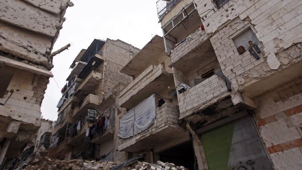 Residents in a government-held part of Aleppo's Salaheddin neighbourhood look out from the balconies of their damaged houses at the road on which the convoy evacuating civilians and rebel fighters from the last rebel-held neighbourhood in the northern Syrian city were supposed to pass - Sputnik International