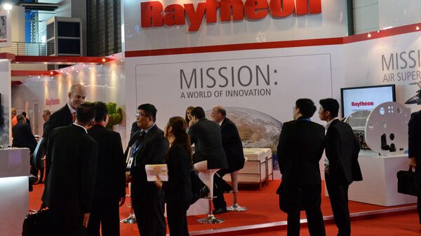 Trade visitors stand in front of a Raytheon booth during the Singapore Air Show. (File) - Sputnik International