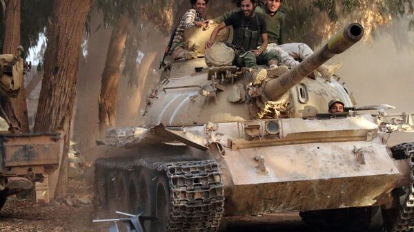 Soldiers from the Libyan National Army, led by Marshal Khalifa Haftar, drive their tank on November 19, 2016 in the Qawarsha sector, 10 kilometres (six miles) west of the centre of Benghazi, after they retook the area from jihadist fighters - Sputnik International