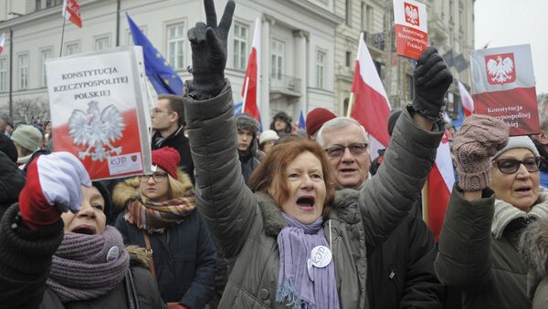 Protesters holding copies of Poland's constitution shout slogans during an anti-government demonstration, in Warsaw, Poland - Sputnik International