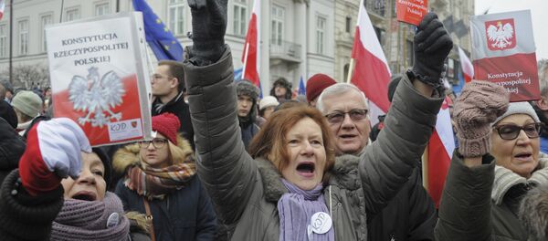 Protesters holding copies of Poland's constitution shout slogans during an anti-government demonstration, in Warsaw, Poland - Sputnik International