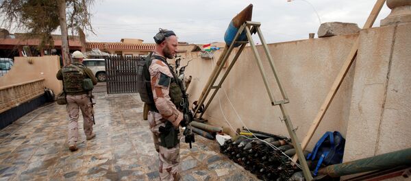 A US soldier looks at weapons and ammunition belonging to Daesh terrorists in the town of Bashiqa, east of Mosul, Iraq, December 14, 2016 A US soldier looks at weapons and ammunition belonging to Daesh terrorists in the town of Bashiqa, east of Mosul, Iraq, December 14, 2016 - Sputnik International