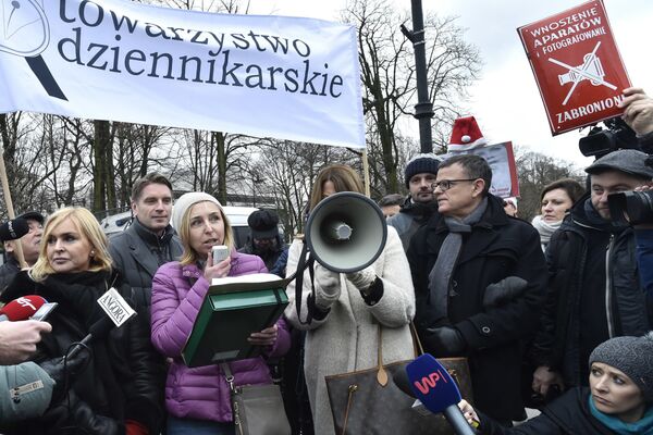 In this Thursday, Dec. 15, 2016 photo a protester raises a communist-era sign reading Photographing Forbidden, during a journalists protest in front of the parliament in Warsaw, Poland, against the ruling Law and Justice party plans to impose new rules starting Jan. 1 that would drastically limit reporters' access in parliament In this Thursday, Dec. 15, 2016 photo a protester raises a communist-era sign reading Photographing Forbidden, during a journalists protest in front of the parliament in Warsaw, Poland, against the ruling Law and Justice party plans to impose new rules starting Jan. 1 that would drastically limit reporters' access in parliament - Sputnik International