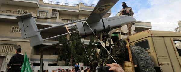 Palestinian militants of the Ezzedine al-Qassam Brigades, Hamas' armed wing, dislpay a drone during a parade marking the 27th anniversary of the Islamist movement’s creation on December 14, 2014 in Gaza City - Sputnik International