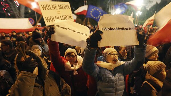 People gather to demonstrate outside the Parliament building in Warsaw, Poland, on Friday Dec. 16, 2016, in support of opposition lawmakers protesting against the ruling party's plans to limit media access to lawmakers - Sputnik International