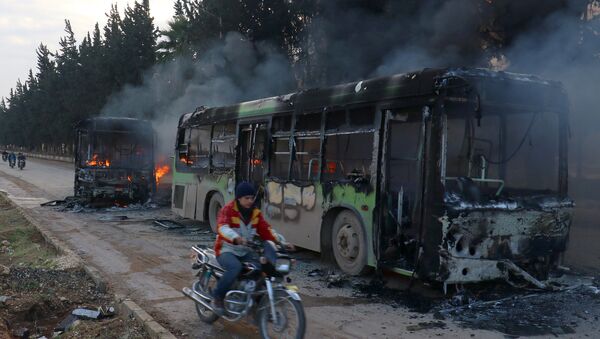 A man on a motorcycle drives past burning buses while en route to evacuate ill and injured people from the besieged Syrian villages of al-Foua and Kefraya, after they were attacked and burned, in Idlib province, Syria December 18, 2016 - Sputnik International