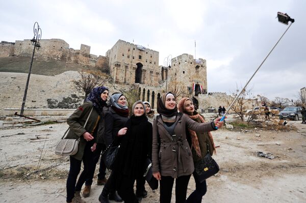 Women take a selfie outside Aleppo's historic citadel, in the government controlled area of the city, Syria December 17, 2016 - Sputnik International