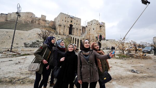 Women take a selfie outside Aleppo's historic citadel, in the government controlled area of the city, Syria December 17, 2016 - Sputnik International
