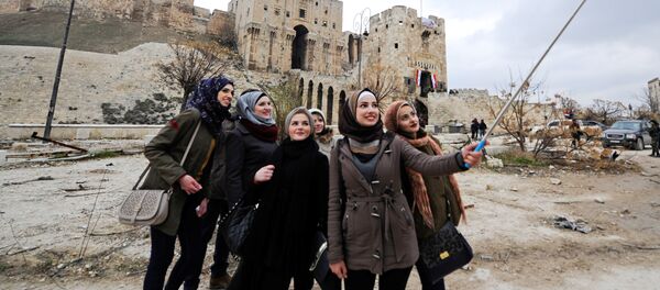 Women take a selfie outside Aleppo's historic citadel, in the government controlled area of the city, Syria December 17, 2016 - Sputnik International
