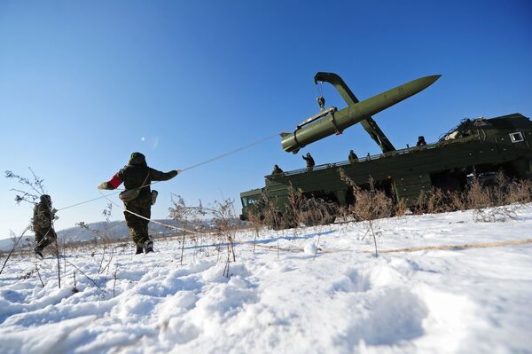 Russian soldiers watch a transporter-loader place an Iskander-M shorter-range missile onto a launcher during an exercise Russian soldiers watch a transporter-loader place an Iskander-M shorter-range missile onto a launcher during an exercise - Sputnik International