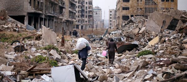 People walk amid the rubble as they carry belongings that they collected from their houses in the government controlled area of Aleppo, Syria December 17, 2016 People walk amid the rubble as they carry belongings that they collected from their houses in the government controlled area of Aleppo, Syria December 17, 2016 - Sputnik International