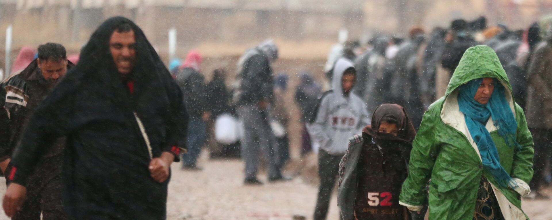 Displaced Iraqis, who fled the Islamic State stronghold of Mosul, walk under rain in Khazer camp, Iraq December 14, 2016 - Sputnik International, 1920, 21.03.2022