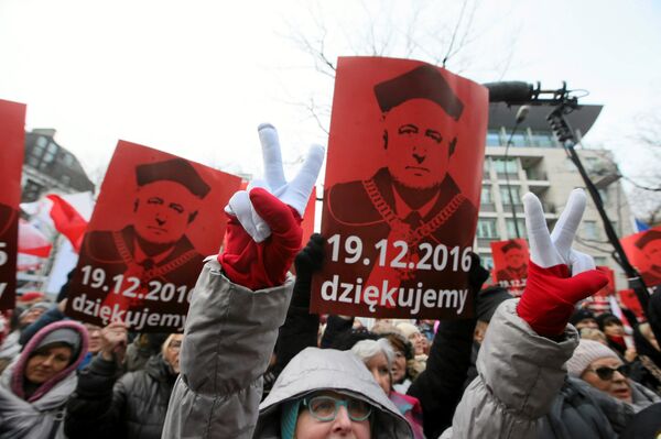 People hold signs with the image of Andrzej Rzeplinski, head of Poland's Constitutional Court, as they take part in demonstration in front of the Constitutional Tribunal in Warsaw, Poland December 18, 2016. People hold signs with the image of Andrzej Rzeplinski, head of Poland's Constitutional Court, as they take part in demonstration in front of the Constitutional Tribunal in Warsaw, Poland December 18, 2016. - Sputnik International