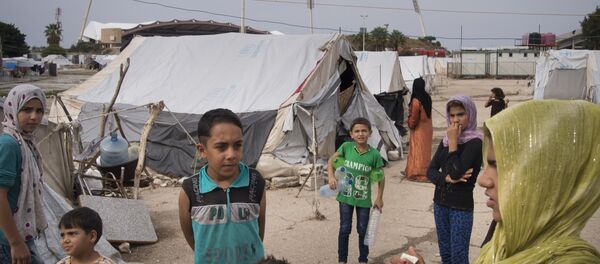 Refugees stand at a camp in Latakia, Syria Refugees stand at a camp in Latakia, Syria - Sputnik International