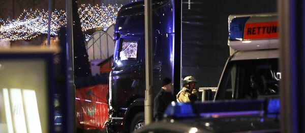 Police stand beside a damaged truck which ran into crowded Christmas market in Berlin, Germany. - Sputnik International
