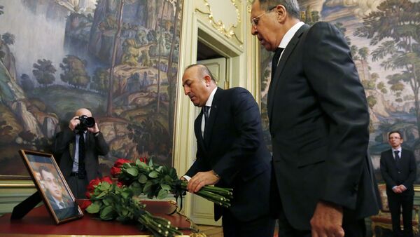 Russian Foreign Minister Sergei Lavrov (R) and his Turkish counterpart Mevlut Cavusoglu lay flowers in front of a photo of Russian ambassador to Turkey, who was killed in Ankara, before their talks in Moscow on December 20, 2016 - Sputnik International