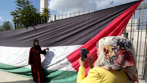 A Palestinian woman takes a picture of a 66-meter-long Palestinian flag - Sputnik International