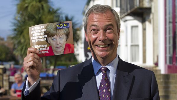 Leader of the UK Independence Party (UKIP) Nigel Farage, poses with a leaflet showing a picture of German Chancellor Angela Merkel in Cliftonville, Margate east of London, as he kicks off their Say No To The EU tour on September 7, 2015, during the party’s referendum campaign. - Sputnik International