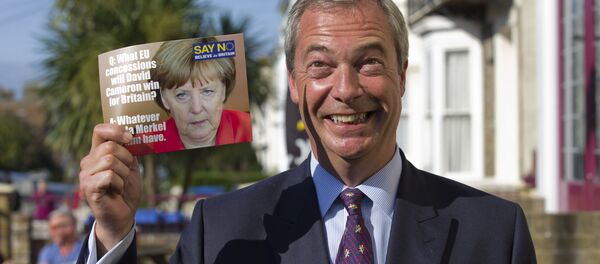 Leader of the UK Independence Party (UKIP) Nigel Farage, poses with a leaflet showing a picture of German Chancellor Angela Merkel in Cliftonville, Margate east of London, as he kicks off their Say No To The EU tour on September 7, 2015, during the party’s referendum campaign. - Sputnik International