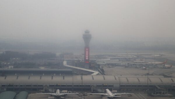 Passenger planes are on the tarmac at the Beijing Capital International Airport shrouded by pollution haze in Beijing, Thursday, Nov. 17, 2016 - Sputnik International