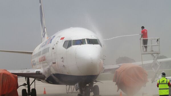Airport employees wash ash from an airplane at Solo airport in Central Java on February 15, 2014, following the volcanic eruption of Mouth Kelud in East Java on February 13 - Sputnik International