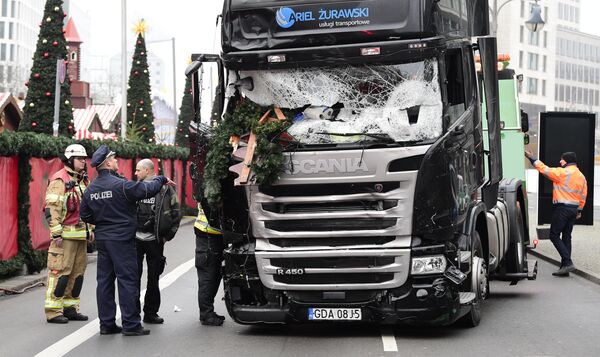 A policeman and firemen stand next to a truck on December 20, 2016 at the scene where it crashed into a Christmas market near the Kaiser-Wilhelm-Gedaechtniskirche (Kaiser Wilhelm Memorial Church) in Berlin A policeman and firemen stand next to a truck on December 20, 2016 at the scene where it crashed into a Christmas market near the Kaiser-Wilhelm-Gedaechtniskirche (Kaiser Wilhelm Memorial Church) in Berlin - Sputnik International