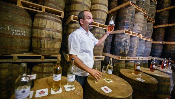 Cuban specialist in Havana Club rum Michel Rodriguez, shows a sample of rum during its maturing process, at a warehouse of the factory of the Cuban rum Havana Club, in San Jose de las Lajas, in the Cuban province of Mayabeque, taken on November 22, 2013 - Sputnik International