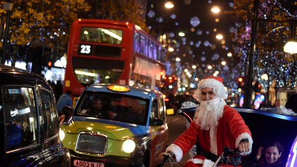 A man dressed as Santa Claus cycles on Oxford Street, which is illuminated with Christmas lights, in London, Britain, December 9, 2016 - Sputnik International