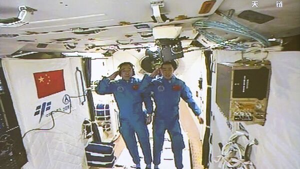 In this image taken off the screen at the Beijing Aerospace Control Center on Wednesday, Oct. 19, 2016 and released by Xinhua News Agency, two Chinese astronauts Jing Haipeng, left and Chen Dong salute in the space lab Tiangong 2 - Sputnik International