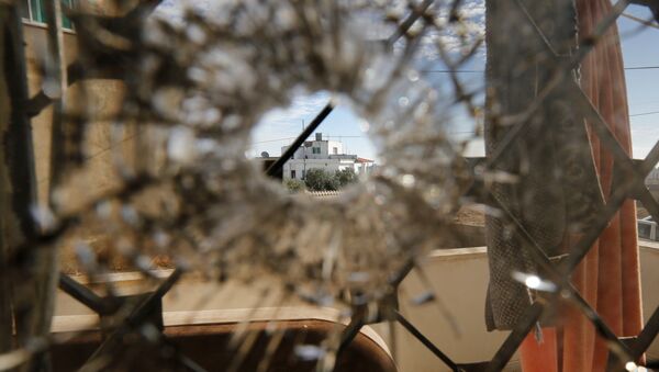 A nearby house is pictured through a bullet hole in a window inside a building that was the site of clashes between Jordanian police and Islamist militant gunmen in the village of Garifla, in Karak, Jordan, December 21, 2016 - Sputnik International