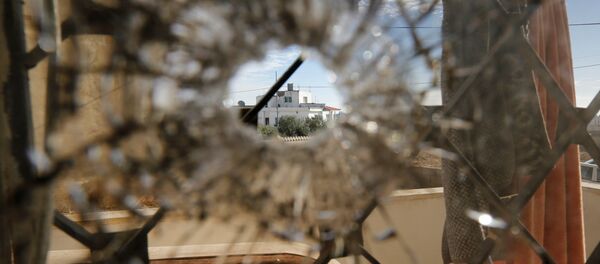 A nearby house is pictured through a bullet hole in a window inside a building that was the site of clashes between Jordanian police and Islamist militant gunmen in the village of Garifla, in Karak, Jordan, December 21, 2016 - Sputnik International
