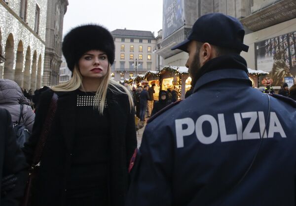 A Police officer patrols a Christmas market next to Milan's gothic cathedral, Italy - Sputnik International